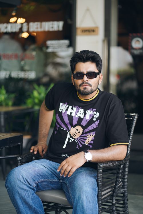 Free Man in sunglasses sitting at a Chandigarh café terrace, relaxed. Stock Photo