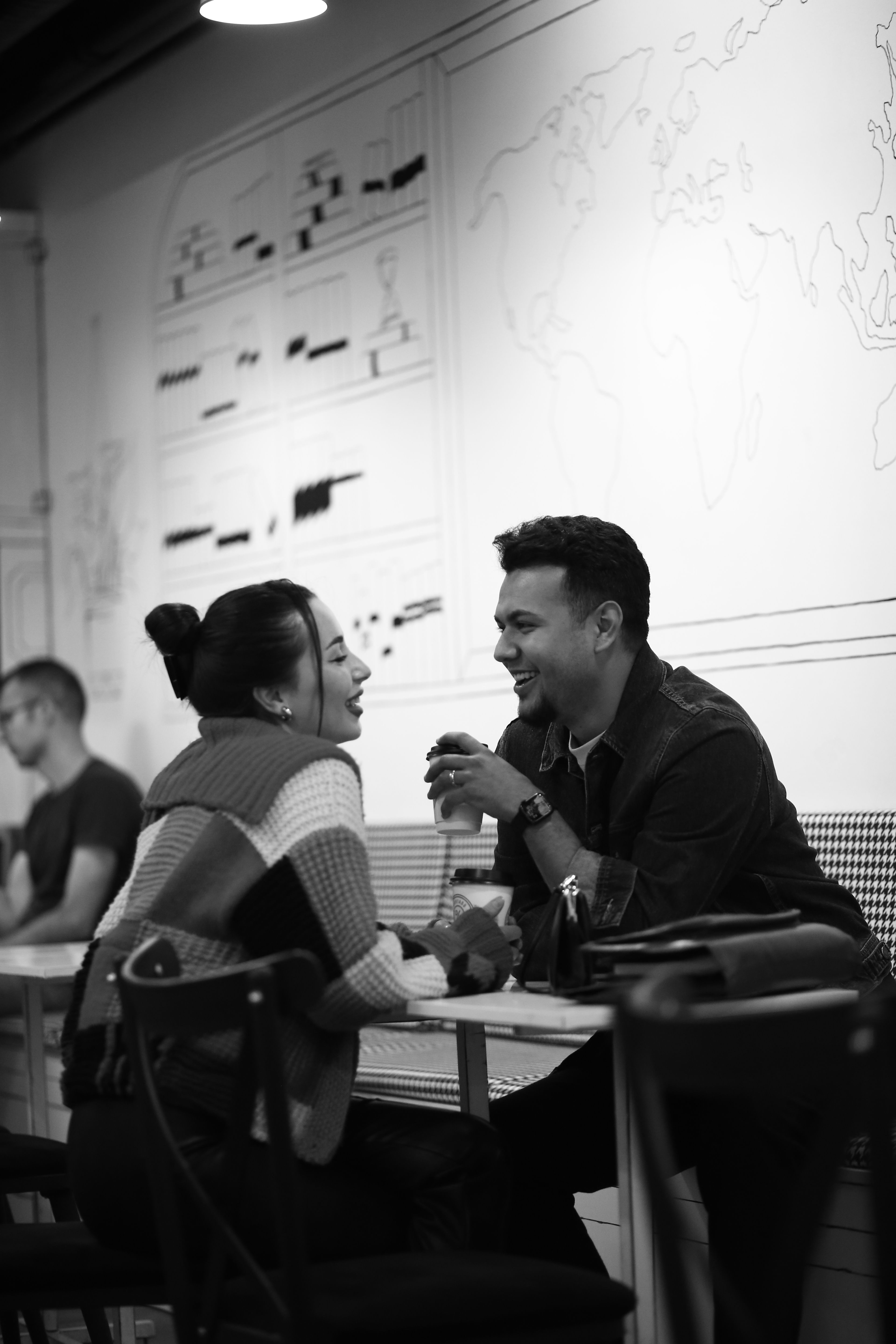 A happy couple shares a moment over coffee in a cozy café.