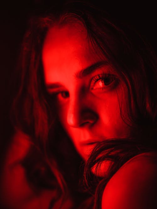 Close-up Portrait of Young Woman in Red Light