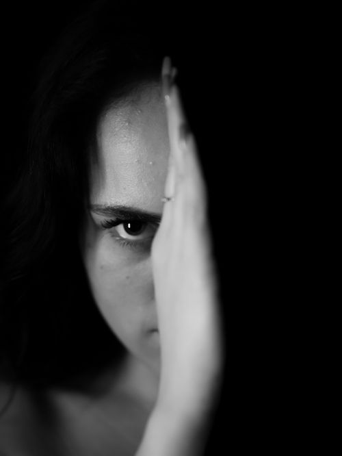 Free Moody black and white portrait of a young woman with dramatic lighting and shadows. Stock Photo