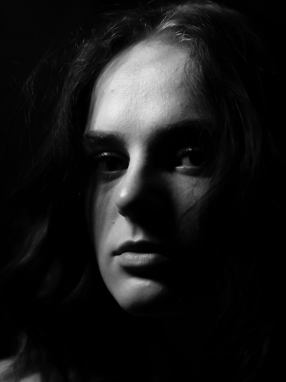 Moody black and white portrait showcasing dramatic lighting and expressive shadows of a young woman.. pexels, moody, black