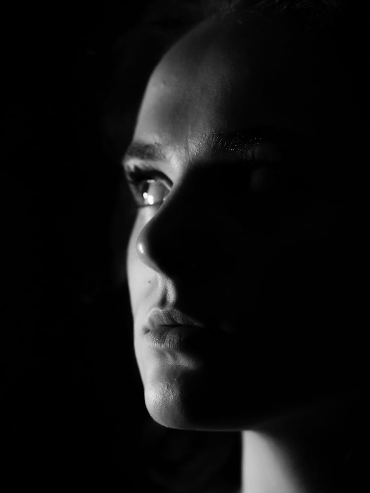 Close-up Portrait Of Young Woman In Dark