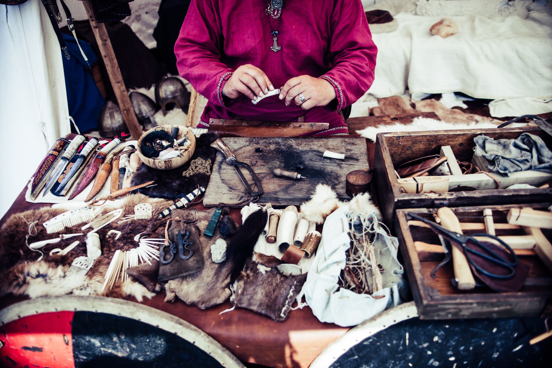 Artisan crafting tools and materials in a traditional workshop setting.