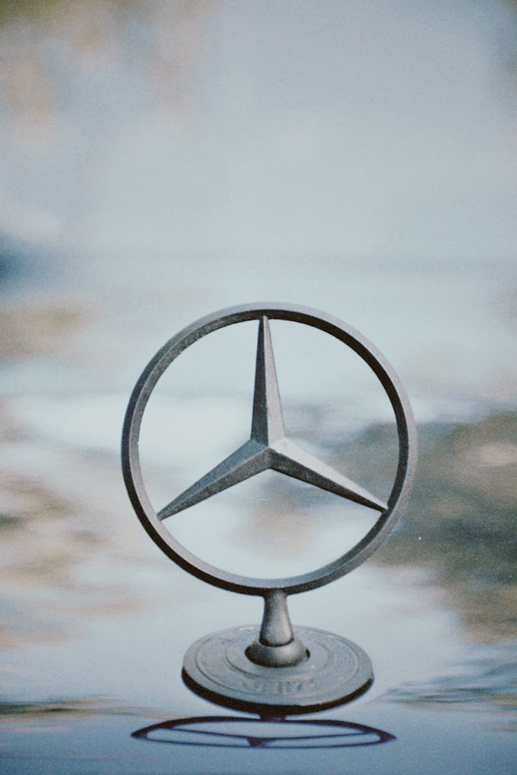 Close-up Of Mercedes Sign On Car Surface