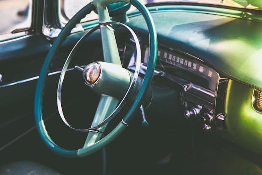 Close-up of a vintage car interior featuring a classic steering wheel and dashboard.