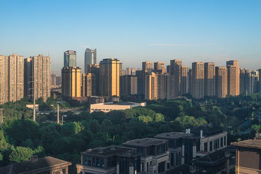 Panoramic view of a modern skyline with prominent skyscrapers and lush greenery.