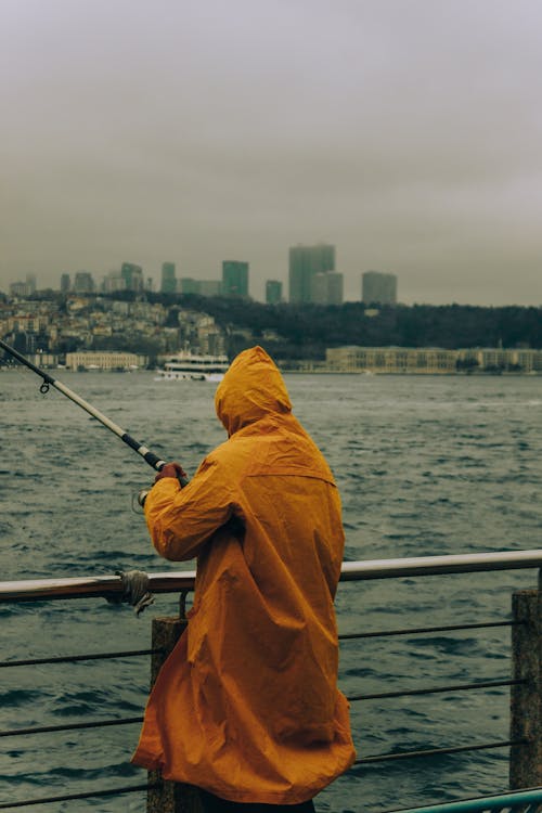 Man in Raincoat with Fishing Rod