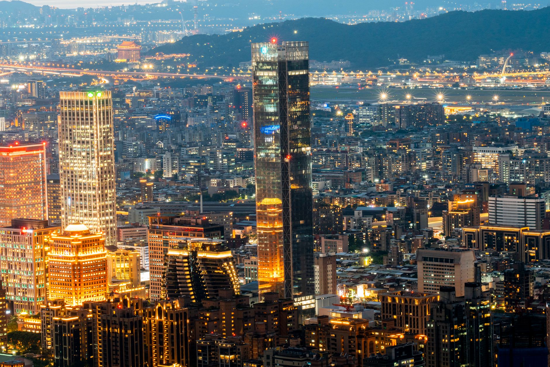 A breathtaking twilight view of Taipei cityscape, featuring illuminated skyscrapers and bustling urban life.