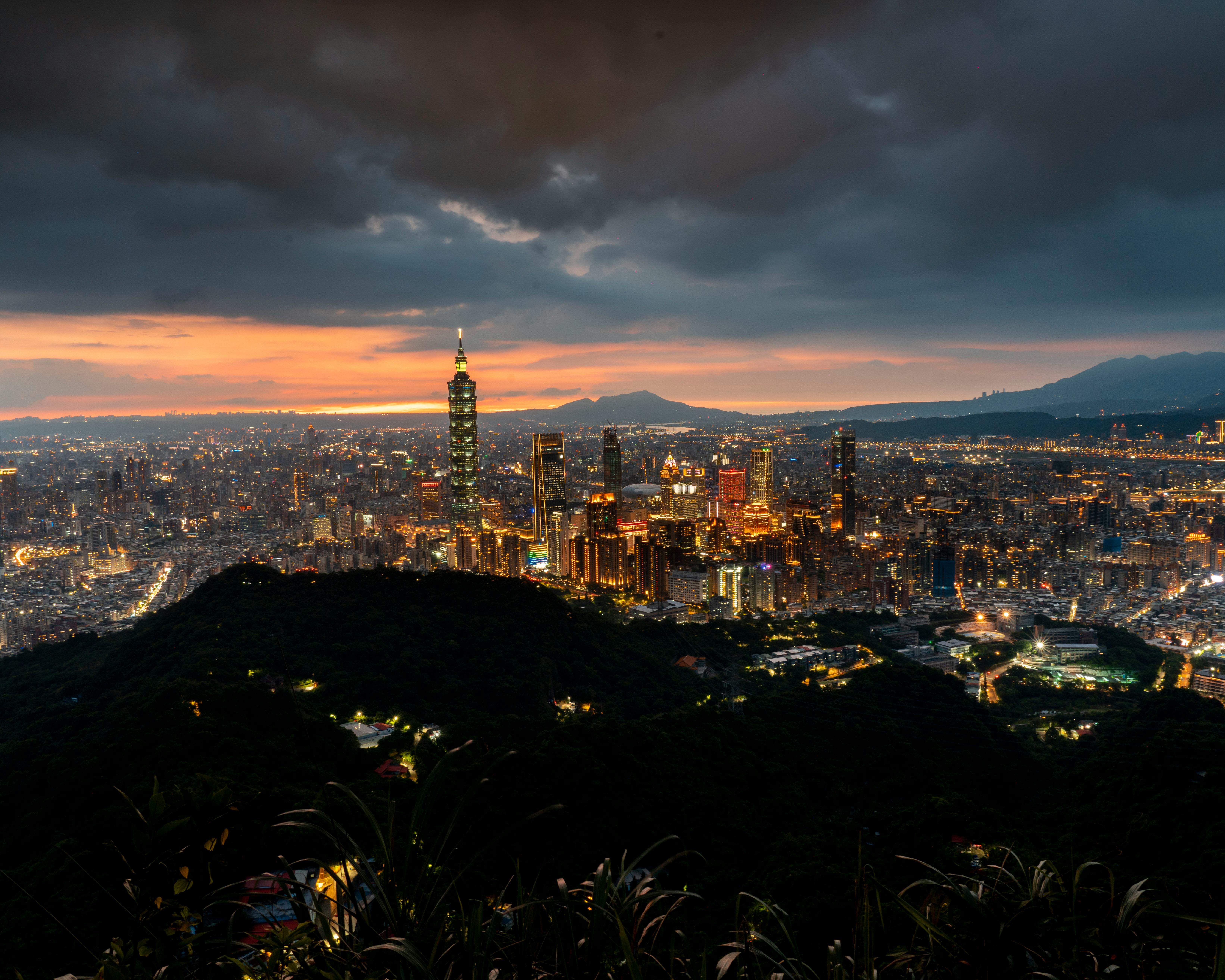 A stunning aerial view of Taipei cityscape with a dramatic sunset sky.