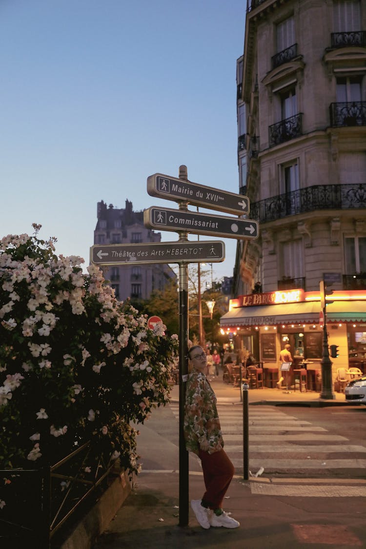 Woman Leaning On Street Sign