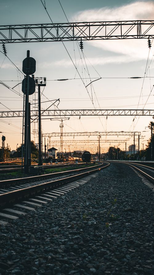 Free Silhouetted railway and power lines at sunset in Kyiv, Ukraine, depicting urban transport infrastructure. Stock Photo