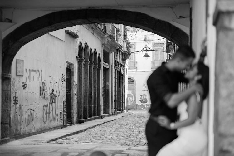 Couple Kissing By Wall In Town In Black And White