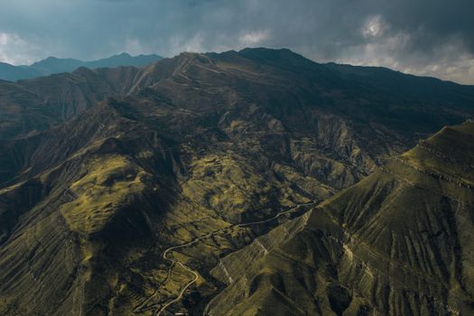 A stunning aerial view capturing rugged mountain landscapes under an overcast sky., free online jigsaw puzzle on JigsawPuzzlesFreeOnline.org