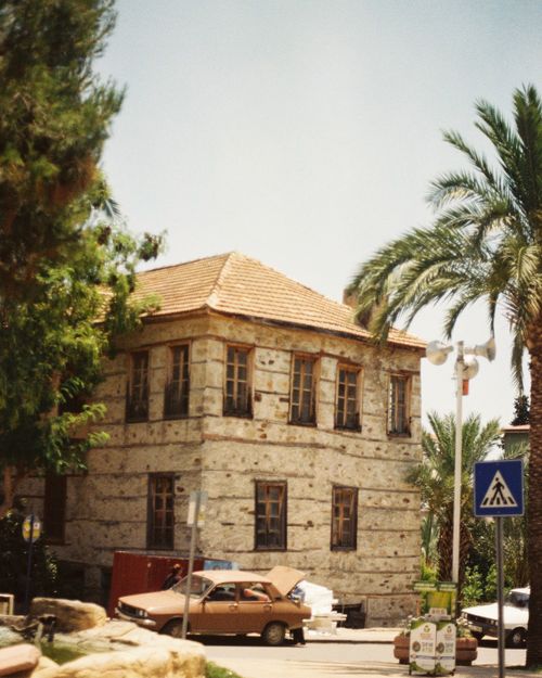 Free Charming street scene in Anamur, Türkiye featuring a classic stone house and palm trees on a sunny day. Stock Photo