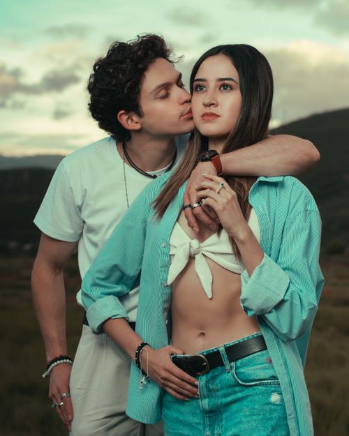 Free A young couple in casual outfits shares a tender moment outdoors, showcasing affection and connection. Stock Photo