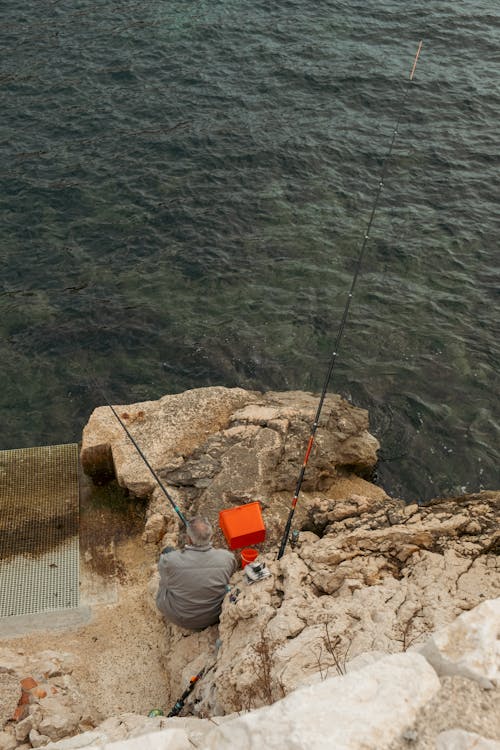 Fisherman Sitting on Rocks