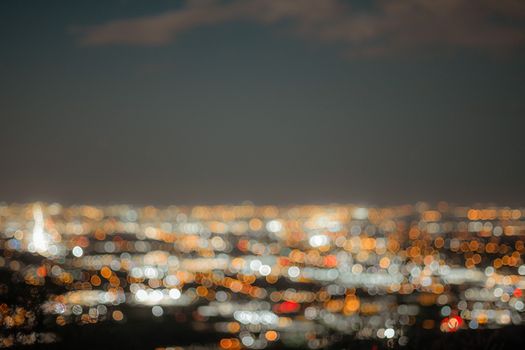 Blurred cityscape with bokeh lights creating a dreamy and abstract night view.