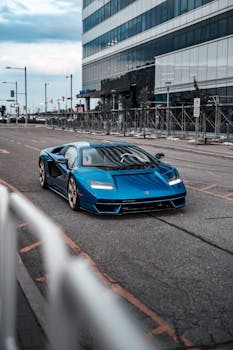 A striking blue Lamborghini Diablo parked on a city street, showcasing modern architecture in the background.