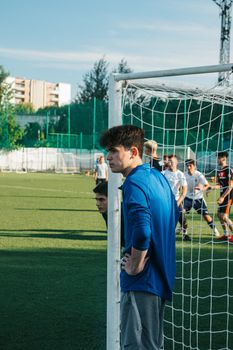 Men playing football on an outdoor field during daytime, engaging in a casual match on a sunny day.
