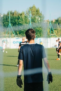 Back view of young soccer players on a field playing a game on a sunny day.