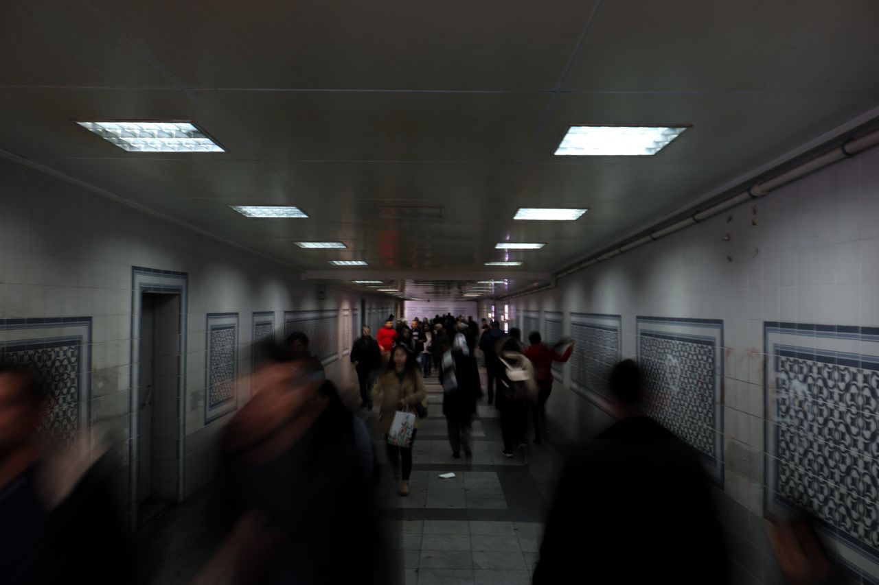 a long exposure of a crowded underground walkway with motion blur capt