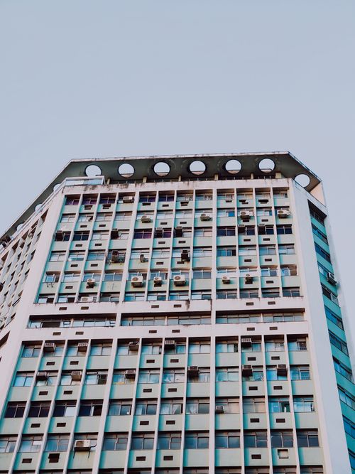 Free Close-up of a skyscraper's facade featuring unique circular rooftop design elements. Stock Photo