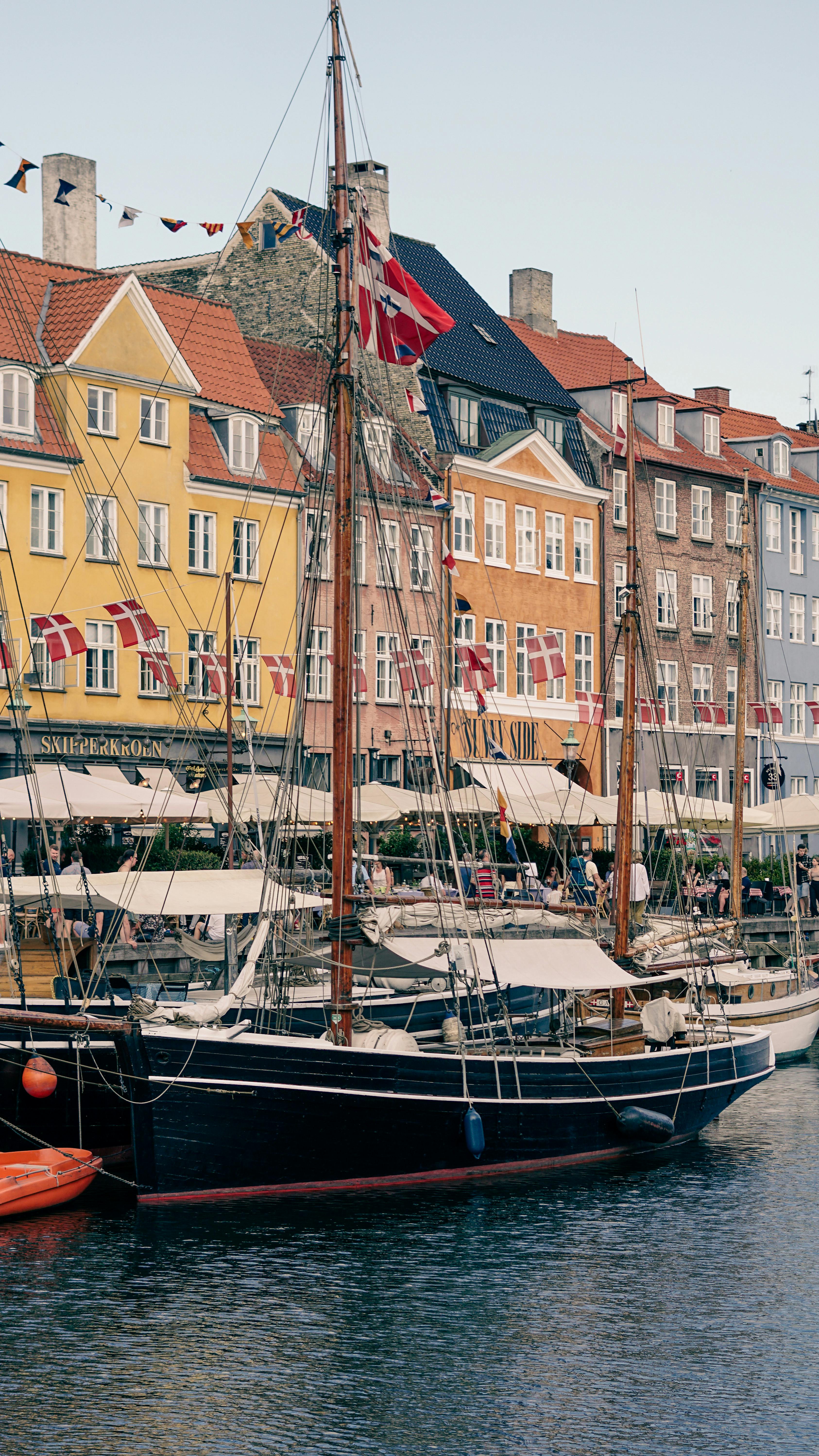Scenic view of Nyhavn Canal in Copenhagen with colorful buildings and sailboats, Denmark.
