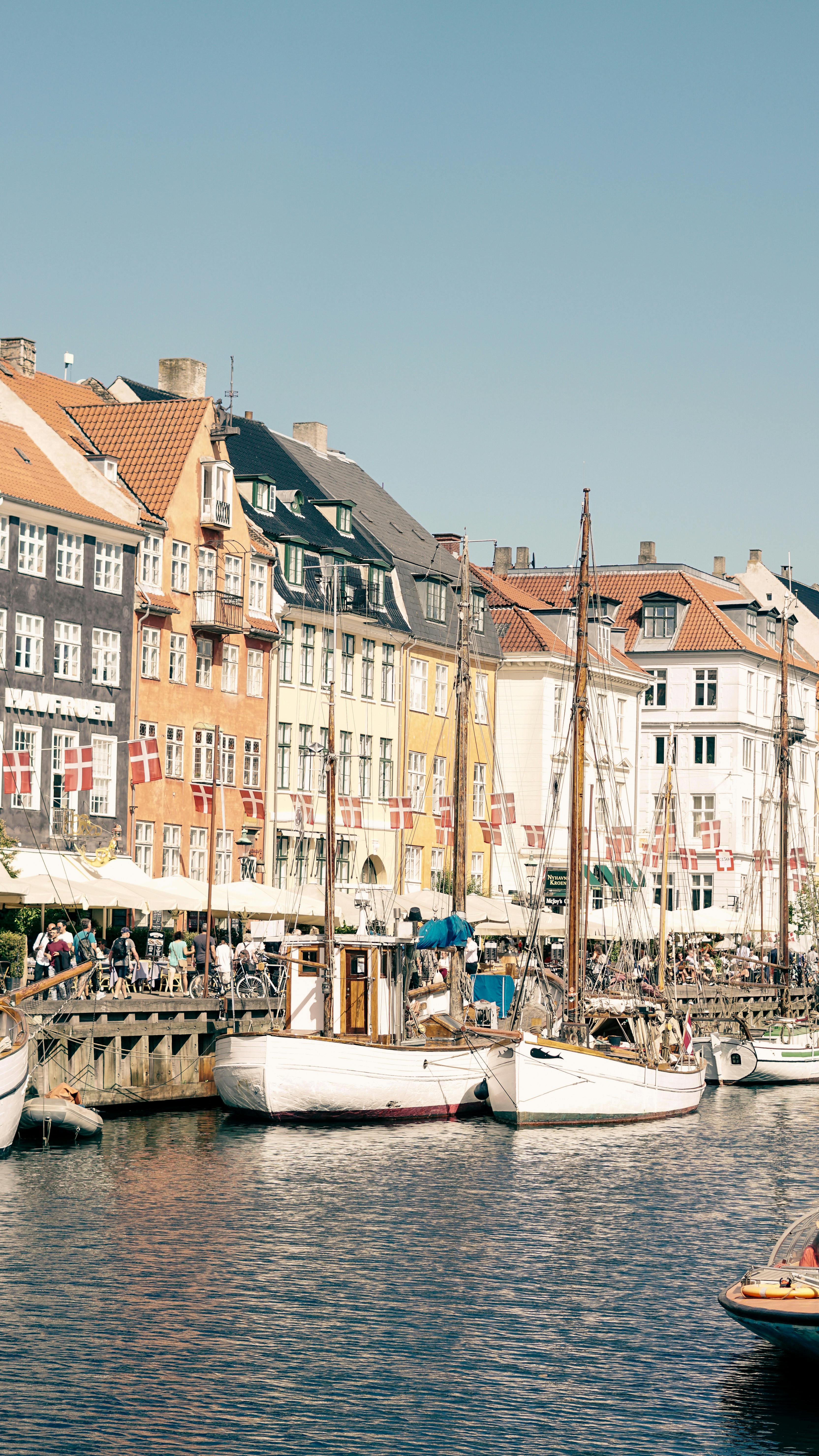 Charming Nyhavn canal with colorful buildings and moored boats in Copenhagen, Denmark.