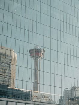 Reflection of Calgary Tower in a modern glass facade building