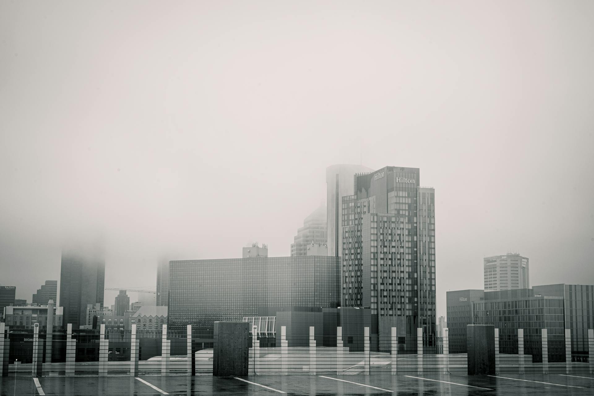 Moody cityscape with Hilton hotel in dense fog, showcasing modern architecture.