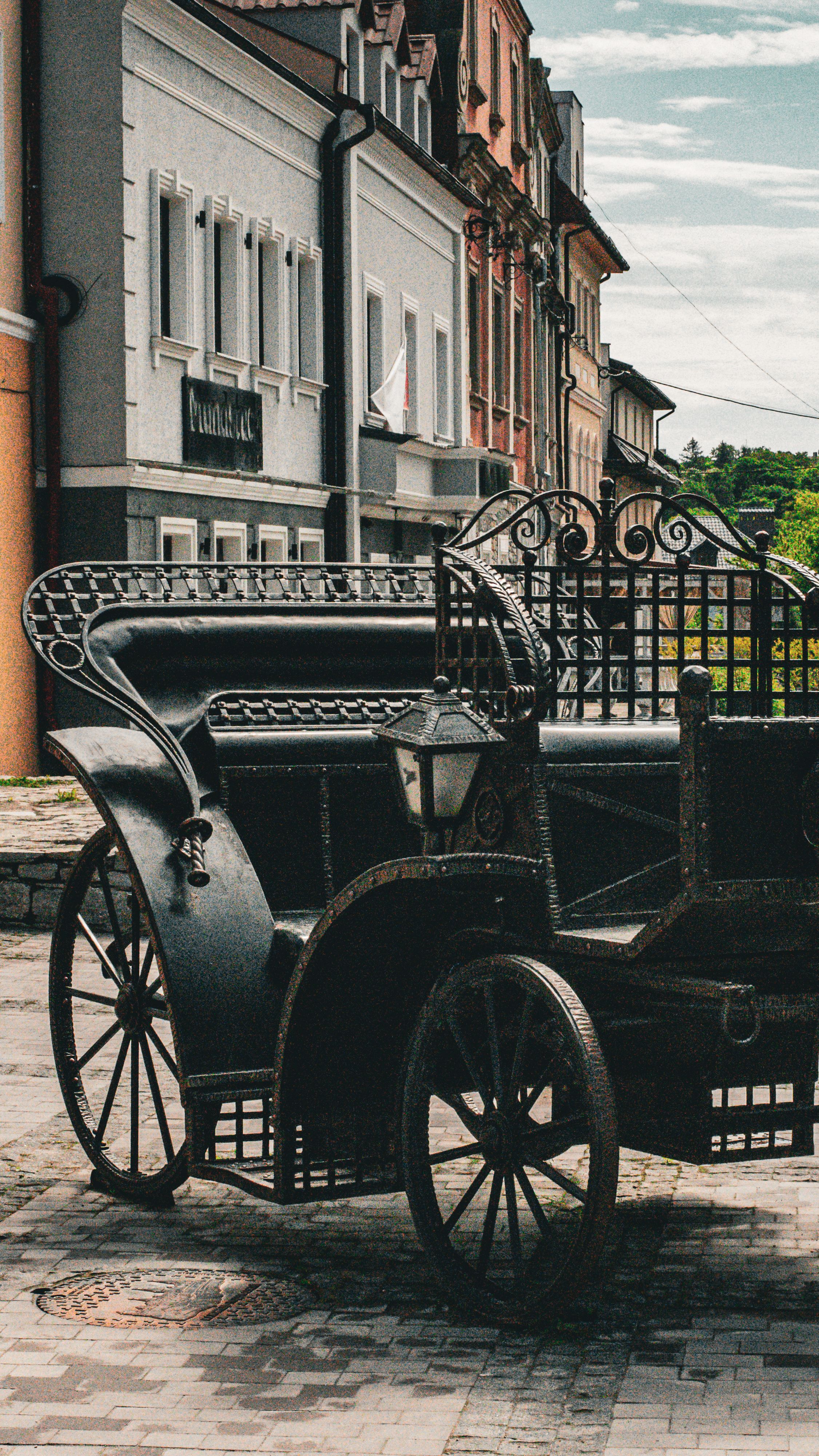 Explore the charm of Kamianets-Podilskyi with this vintage carriage set against historic architecture.