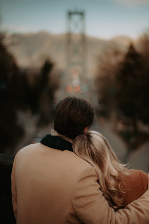 Man Embracing Woman against Blurred Cityscape