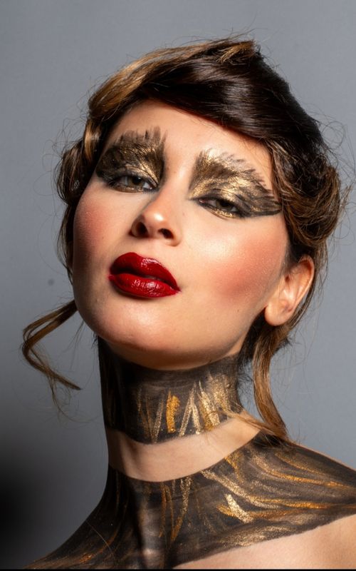 Free Striking portrait of a woman with bold gold and red makeup, ideal for beauty or fashion themes. Stock Photo