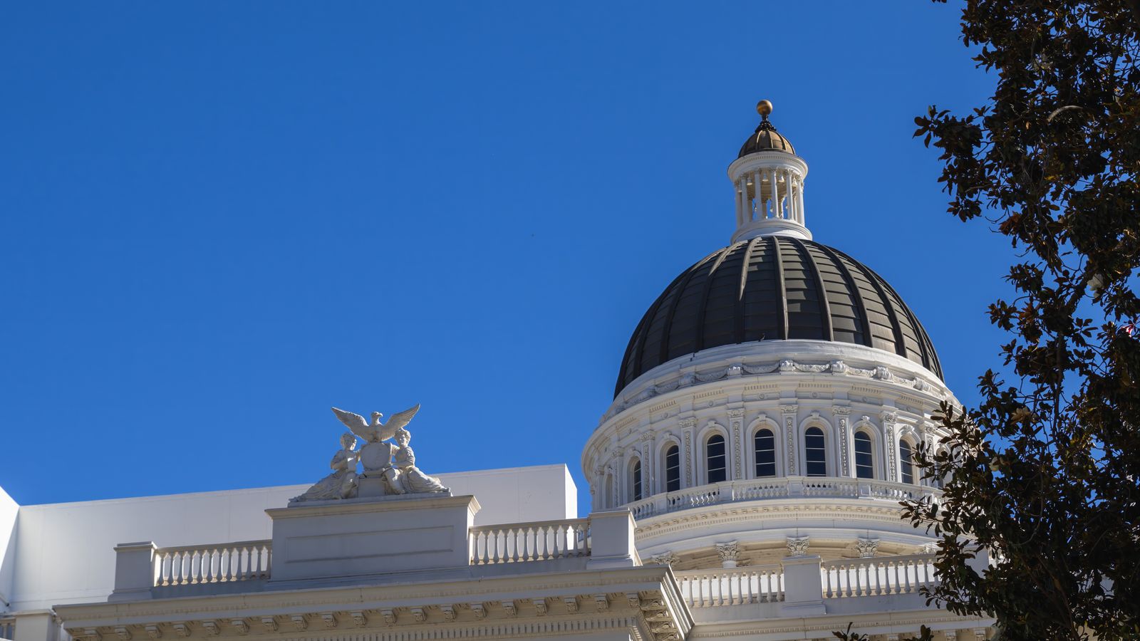 Elegant neoclassical architecture of California State Capitol dome against a vibrant blue sky.