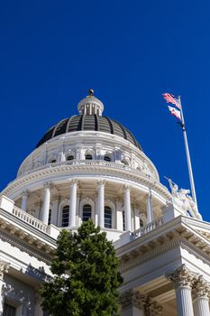 Elegant capitol dome with columns under a clear blue sky, showcasing classic architecture.