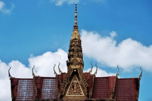 Detailed view of a traditional Cambodian temple roof architecture under a clear blue sky.