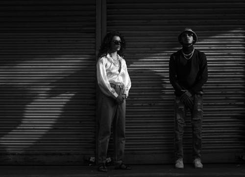 Young Man and Woman in Fashionable Outfits Posing in City 