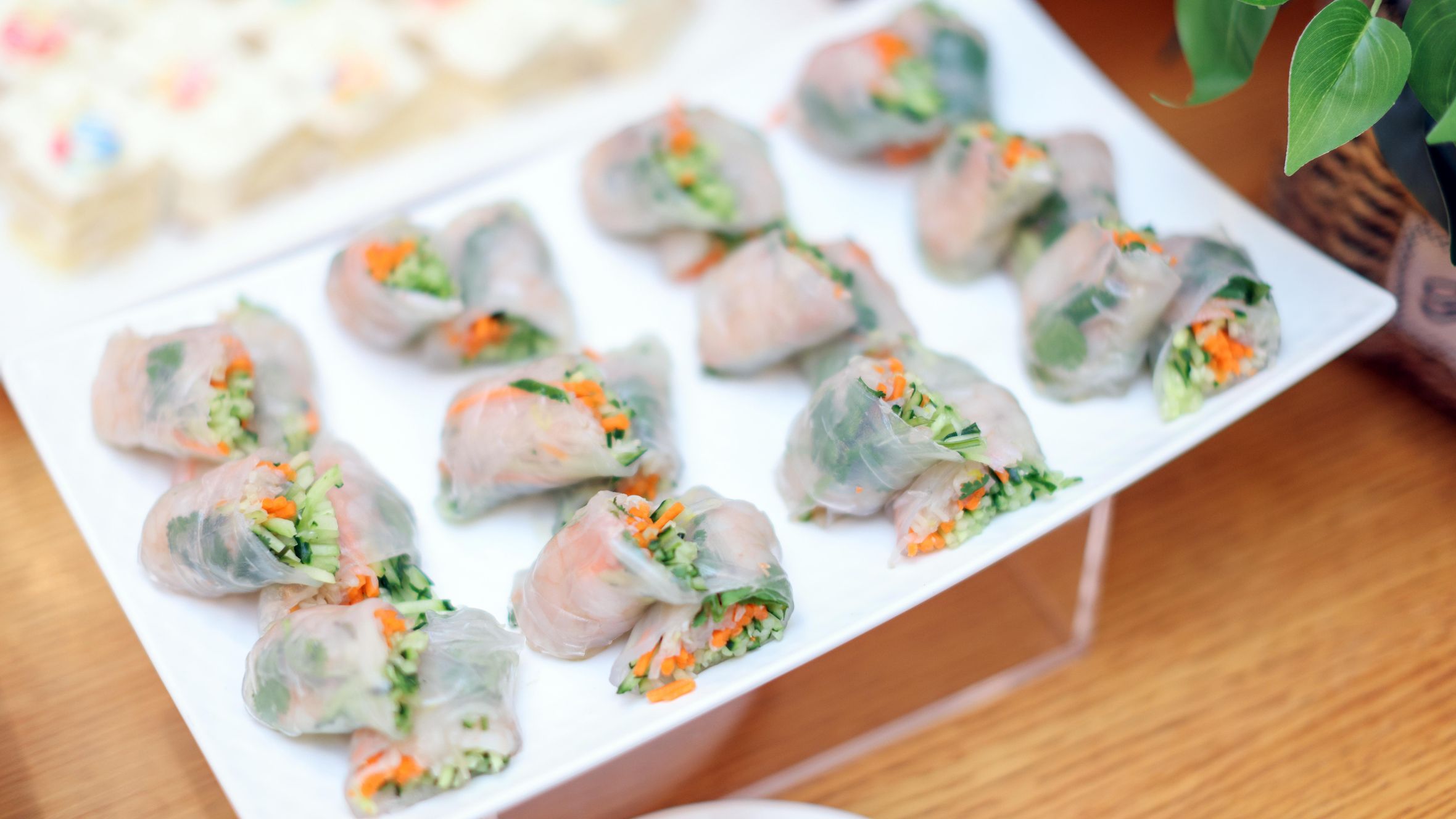 Delicious Vietnamese spring rolls filled with fresh vegetables on a white plate, perfect for a healthy meal.