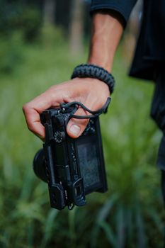 A photographer holds a camera in a natural outdoor setting. Perfect for photography themes.