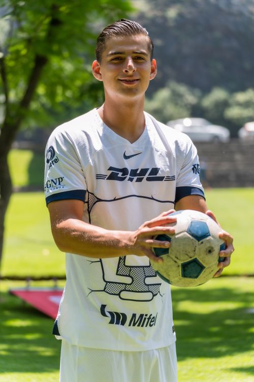 Free Young soccer player holding a football on a sunny day in the park. Stock Photo