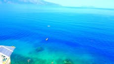 从宁静的鸟瞰视角中，可以看到皮划艇运动员在阳光明媚的日子里畅游于碧绿的大海