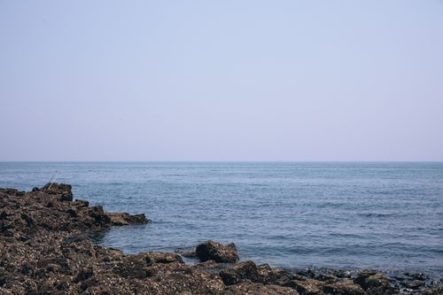 Free Serene rocky coastline in Dalian, China under a clear summer sky, perfect for relaxation. Stock Photo