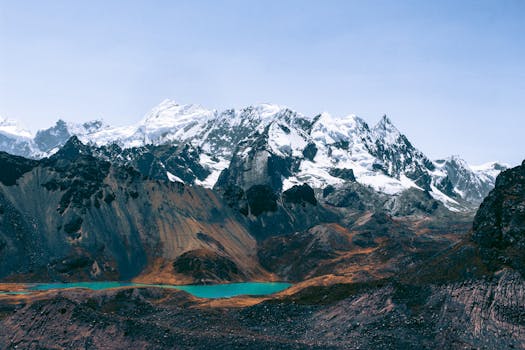 Breathtaking view of Peruvian Andes with snow-capped peaks and glacial lake.