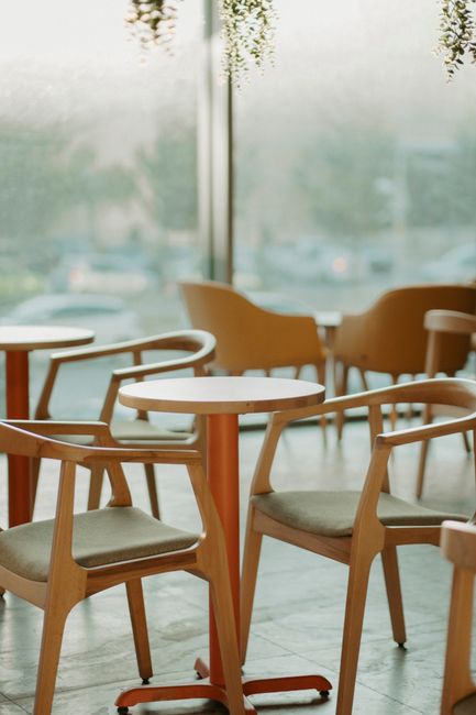Chic modern café interior featuring wooden tables and chairs with natural light.