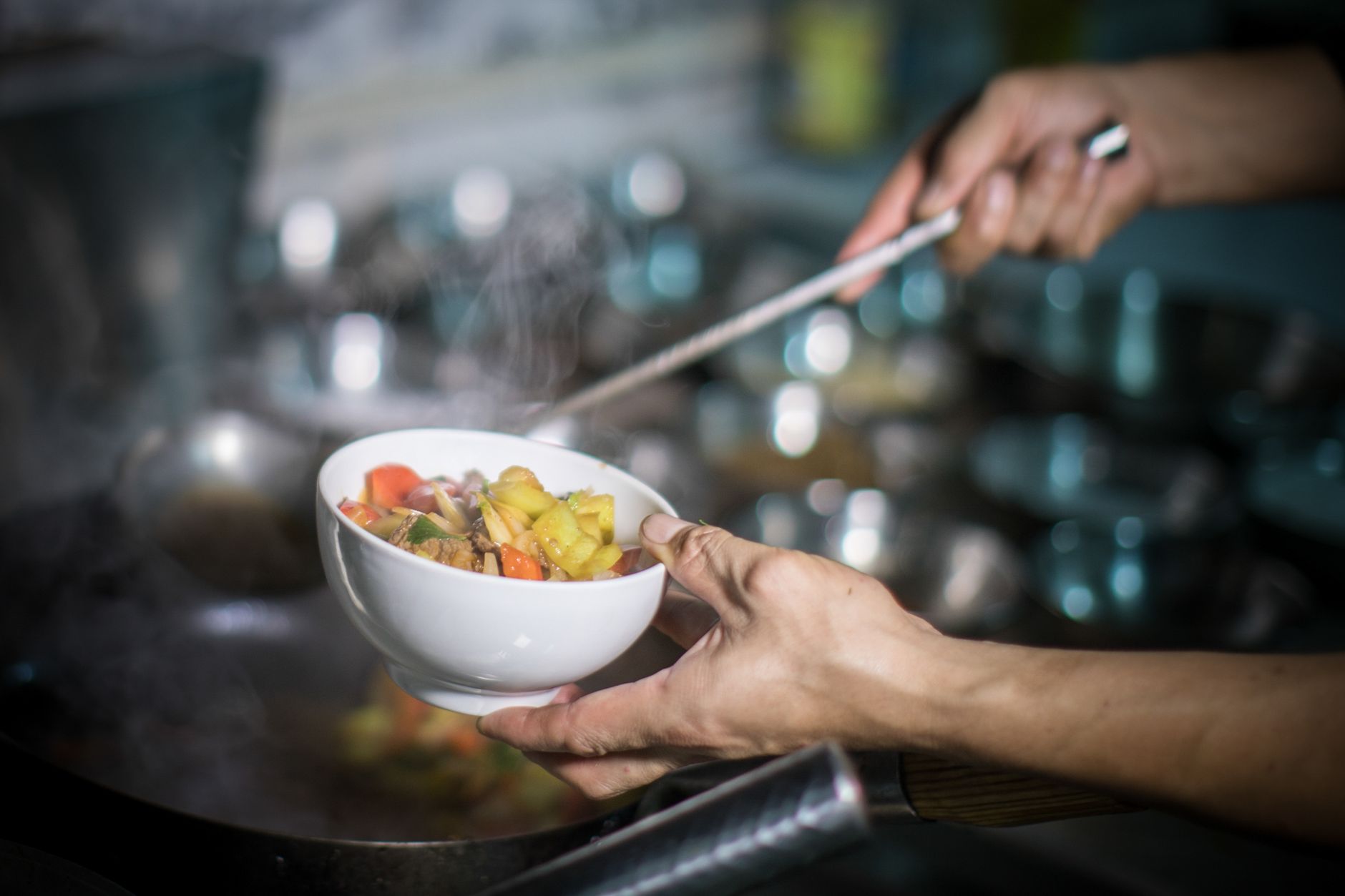 A chef skillfully prepares a fresh vegetable stir-fry in a bustling kitchen.