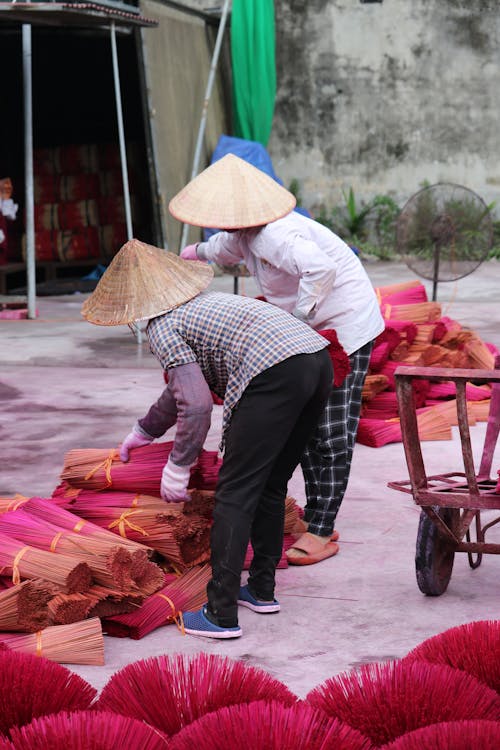 Women in Conical Hats Working with Incense
