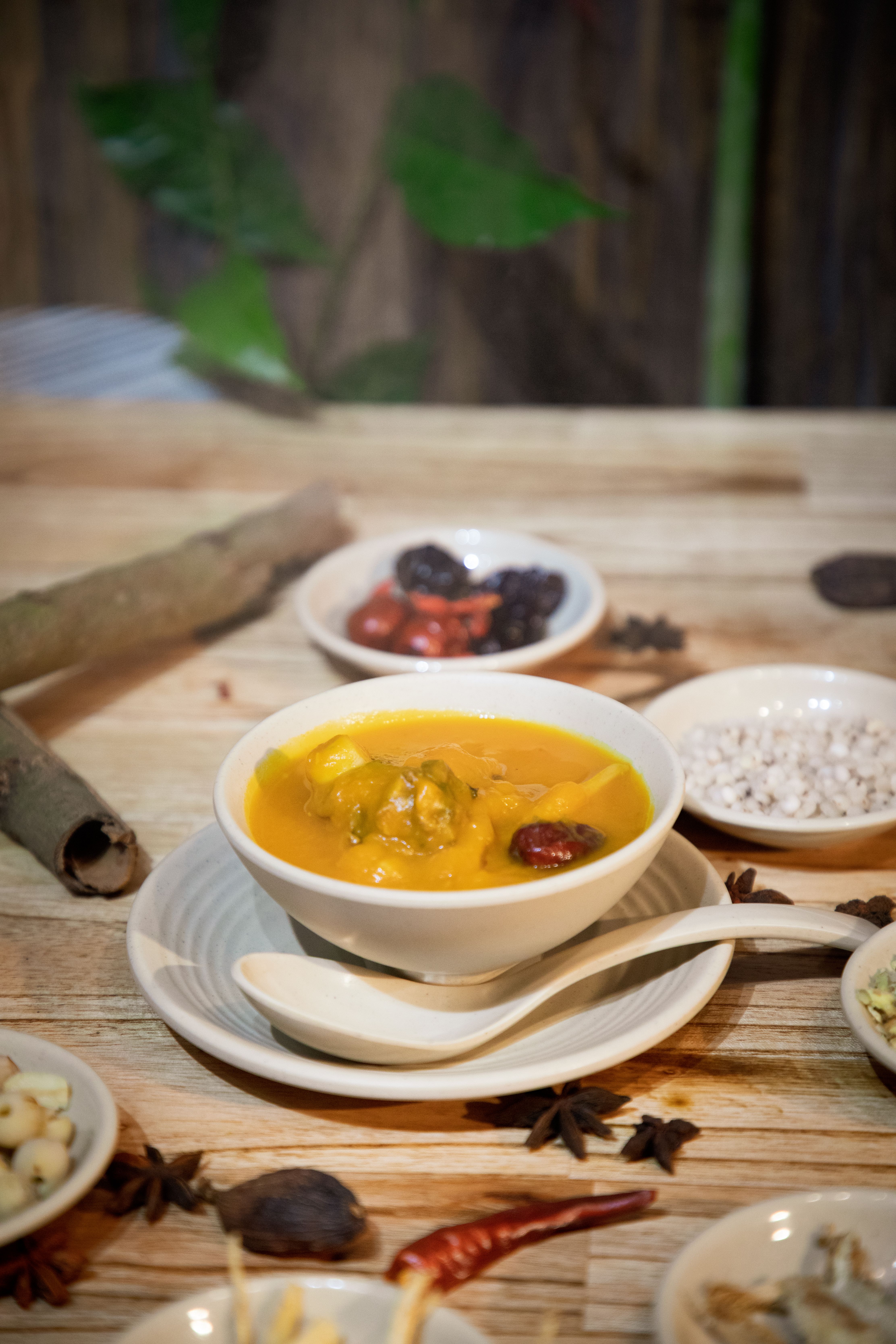 Savory homemade pumpkin stew served in a white bowl with aromatic spices on wooden table.