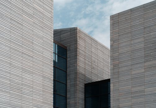 Contemporary minimalist building facade with clear sky background, architectural elegance.