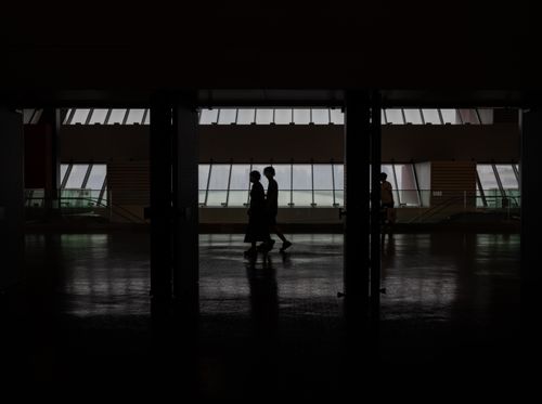 Free Silhouette of people walking through a modern hallway with large windows in Shanghai, China. Stock Photo