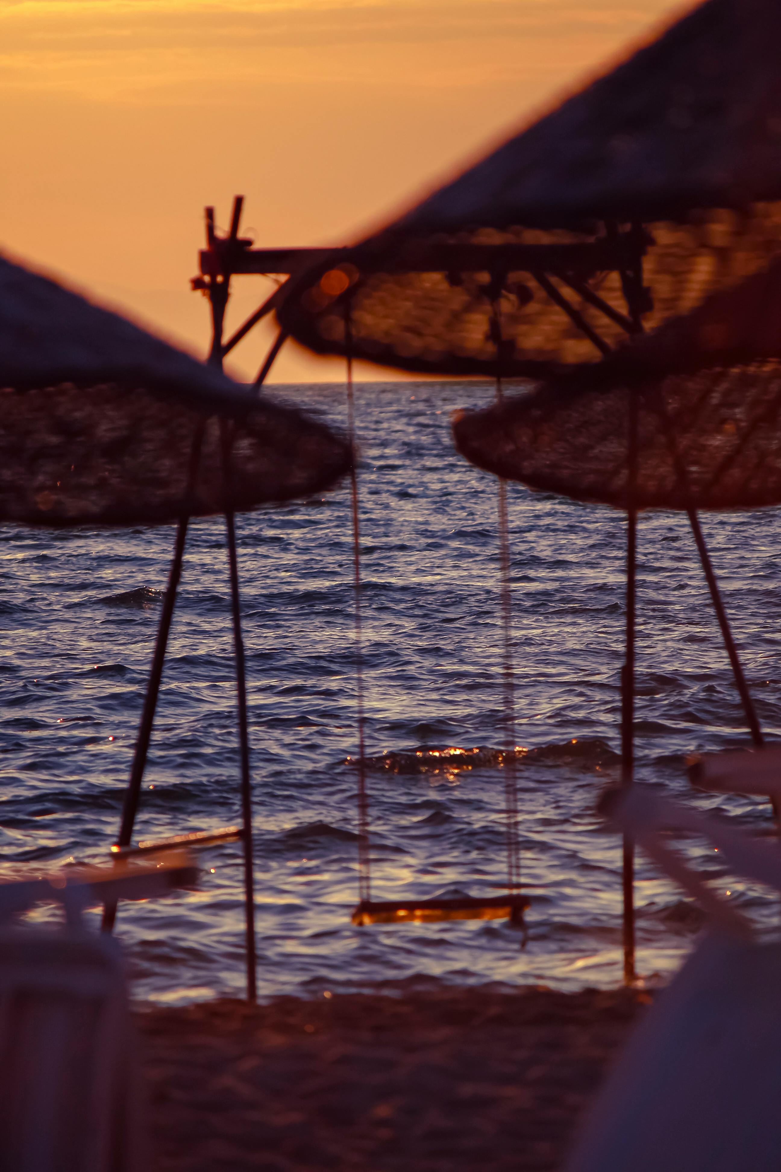 a swing on the beach at sunset